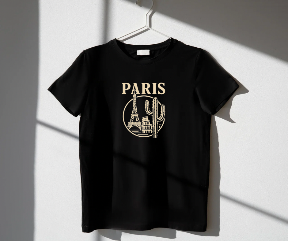 Black t-shirt with 'PARIS' and skyline design on a hanger against a white wall.