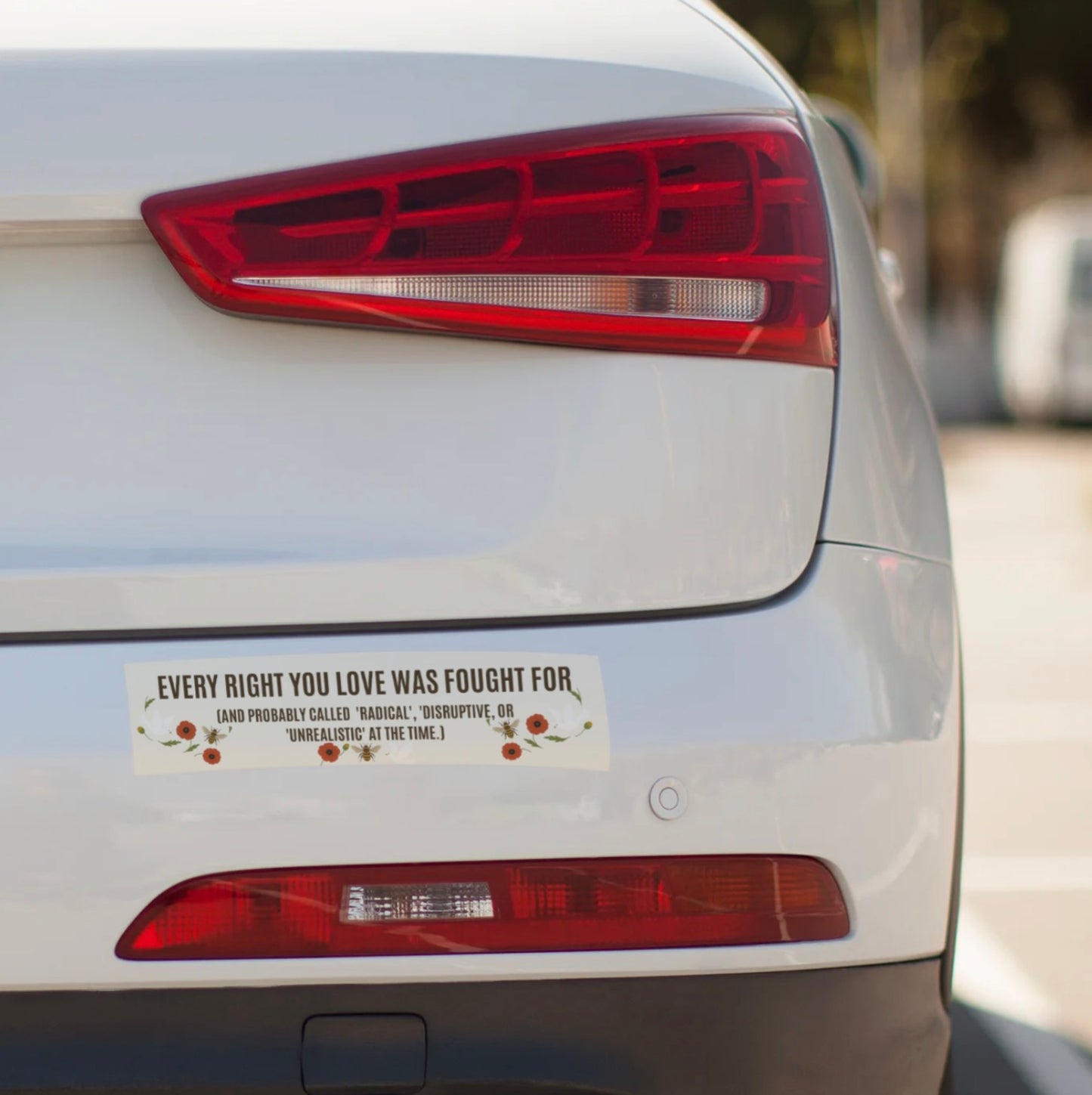 Car's rear with a bumper sticker on a blurred background