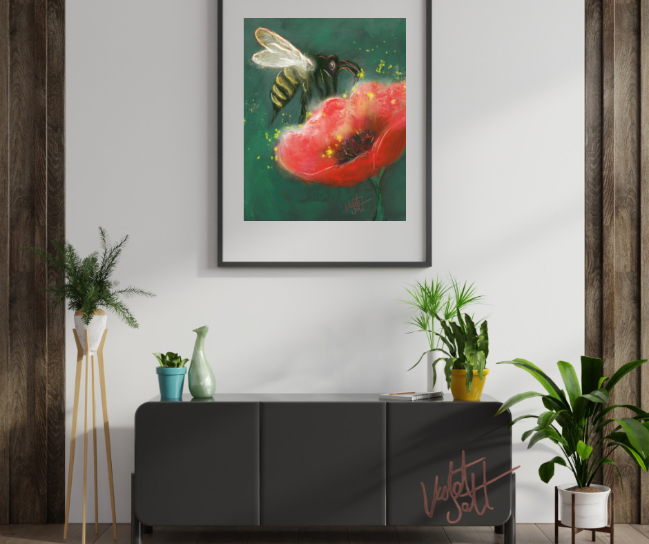 Framed artwork of a bee on a red flower above a dark gray cabinet with plants around.