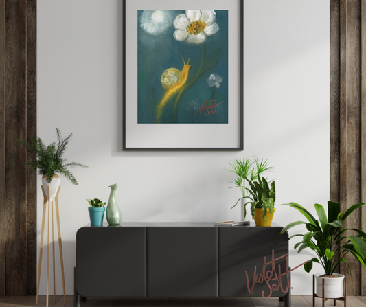 Framed artwork of a snail on a flower above a dark gray cabinet with plants around.