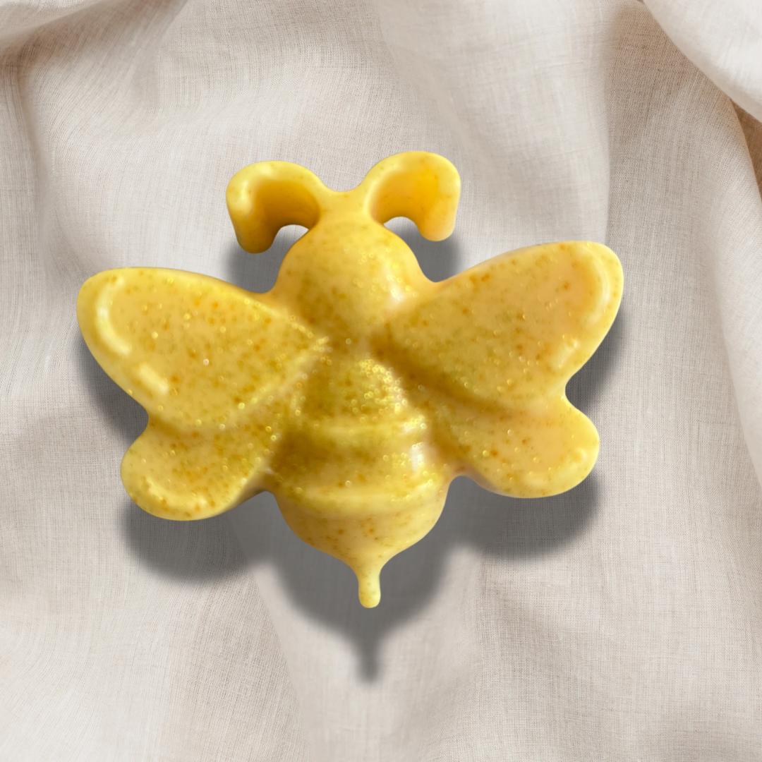 Yellow bee-shaped soap on a light fabric background