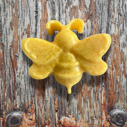 Yellow bee shaped soap on a wooden surface