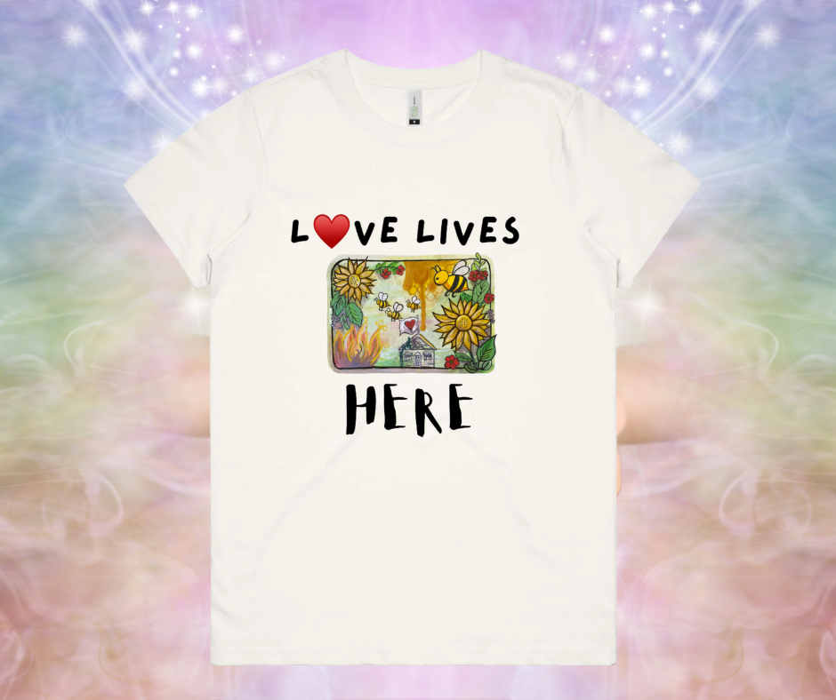 White t-shirt with 'Love Lives Here' text and colorful design on a multicolored background